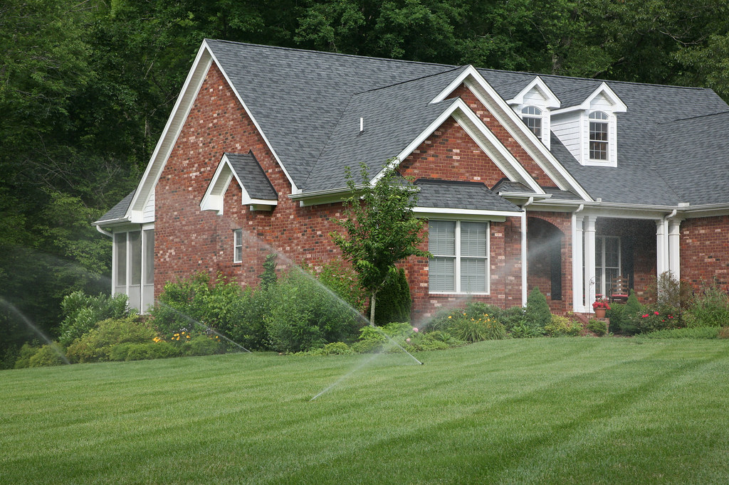 Reticulation sprinklers watering a front lawn